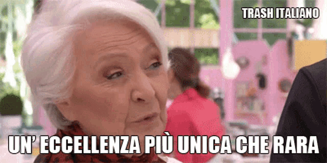 an elderly woman says trash italiano in a pink room
