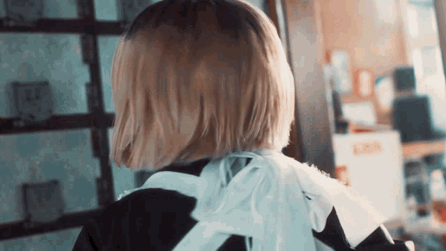 a woman with short blonde hair is wearing a black and white outfit