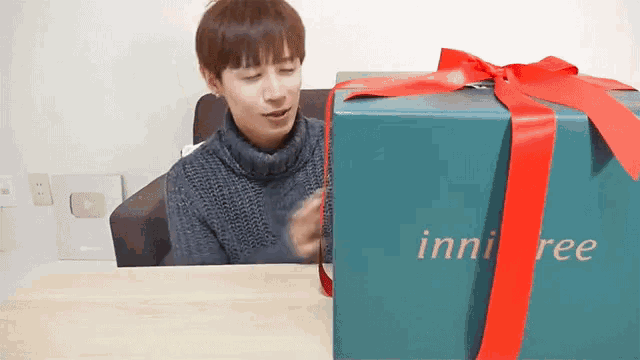a man is opening a gift box that says innisfree on it