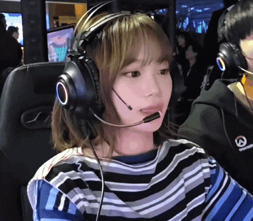 a woman wearing headphones and a shirt that says ' overwatch ' on it