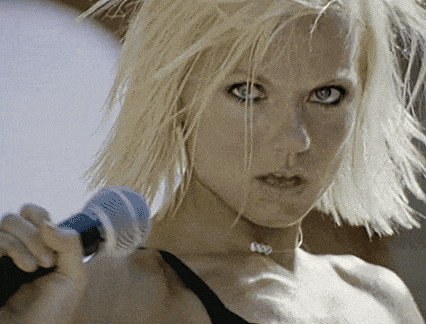 a woman with blonde hair holds a microphone in her hand