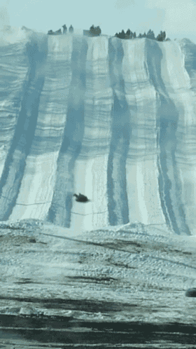 a snowmobile going down a snowy hill