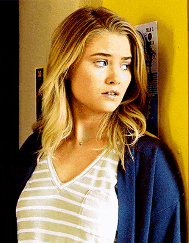 a woman is standing in front of a yellow wall with a poster that says teen 1 on it