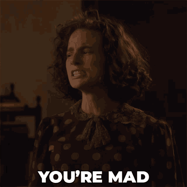 a woman in a polka dot dress says " you 're mad " in white letters