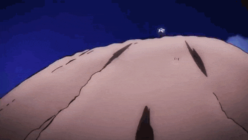 a person is standing on top of a mountain with a blue sky behind them .