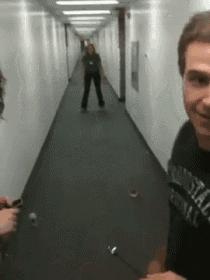 a man wearing a shirt that says ' abercrombie & fitch ' is standing in a hallway