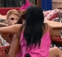 a woman in a pink tank top is sitting next to a woman in a pink tank top .
