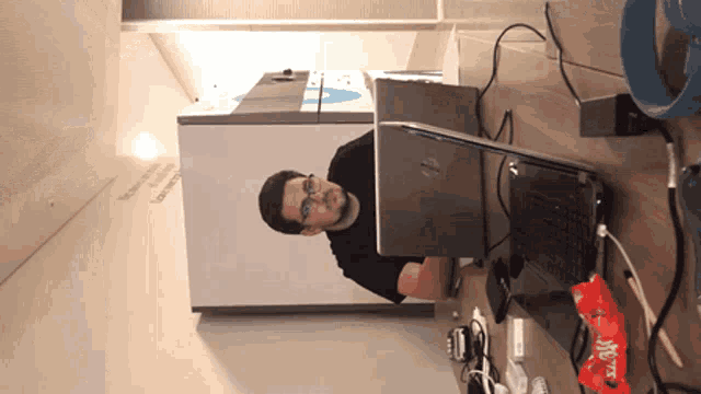 a man sitting in front of an hp laptop computer