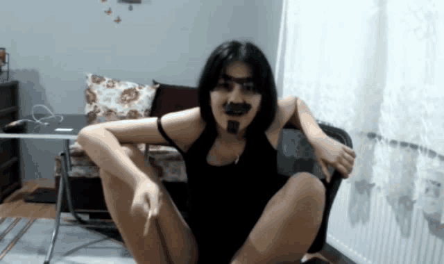 a woman with a fake mustache sits in a chair