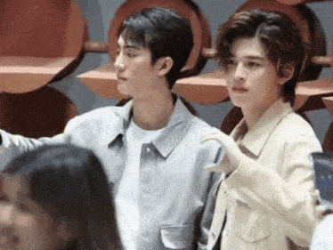 a couple of young men standing next to each other