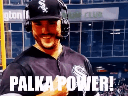a man wearing a hat and headphones is standing in front of a building and says palka power .