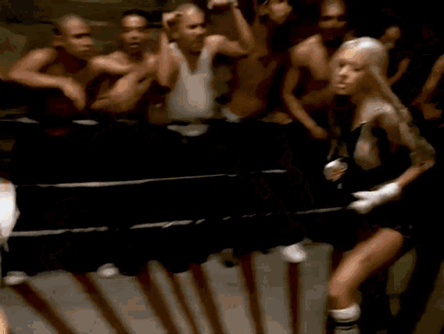 a woman in boxing gloves stands in front of a crowd