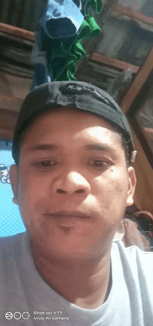 a man wearing a black hat is taking a selfie on a vivo al camera