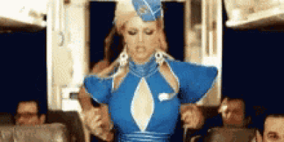 a woman in a blue stewardess costume is standing on an airplane .