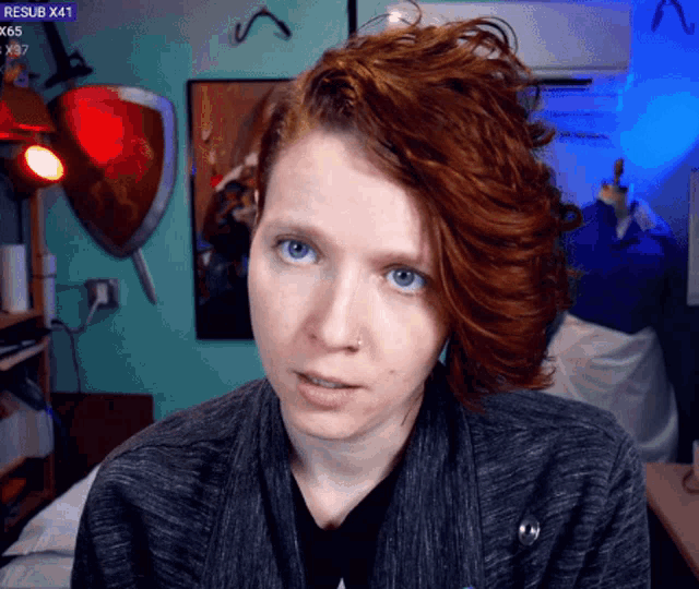 a woman with red hair looks at the camera with rexsub x41 in the upper right corner