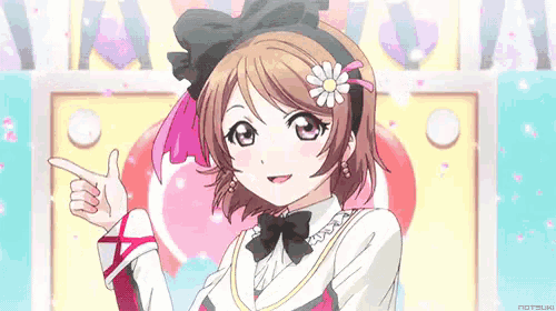 a girl with short hair and a flower in her hair is pointing at something .