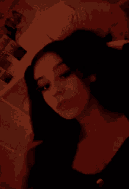 a woman is taking a selfie in a dark room with a stuffed animal in her hair .