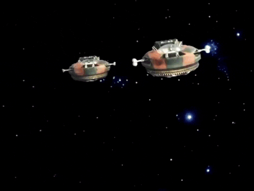 a black object is flying through the air with a white object in the background
