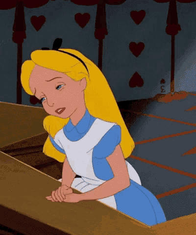 alice from alice in wonderland is sitting at a table