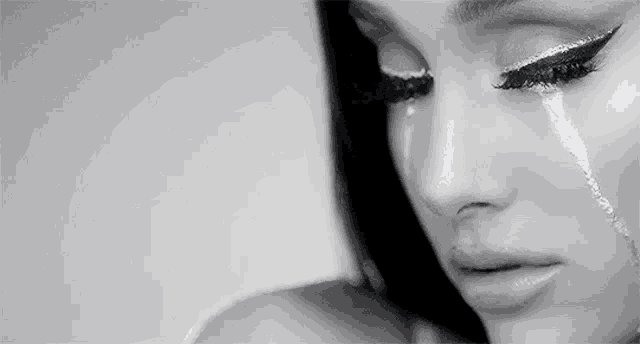 a close up of a woman 's face with a tear running down her cheek .