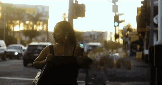 a woman is walking down a street with a sign that says no parking