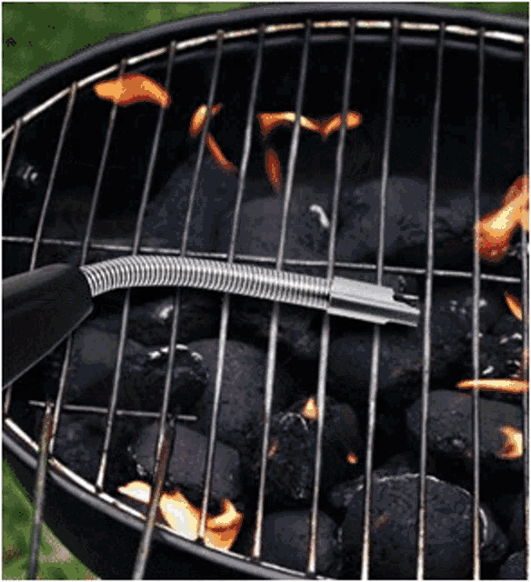a grill with a hose attached to it is being used to cook charcoal