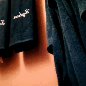 two shirts hanging on a wall one of which says " only you " on it