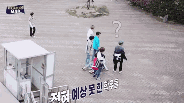 a group of people are walking down a brick sidewalk with a treasure map sign above them