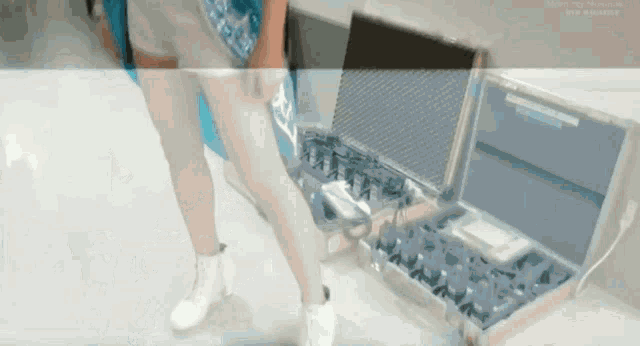 a woman is standing next to a briefcase with a laptop in it