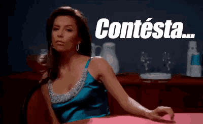 a woman in a blue dress is sitting at a table with the words contesta written above her