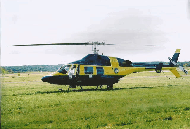 a yellow and black helicopter is parked on a runway