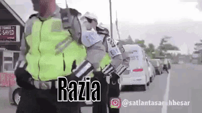 a police officer is standing next to another police officer on the side of a road .