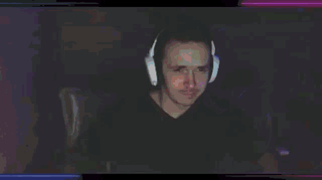a man wearing headphones is sitting in front of a computer .