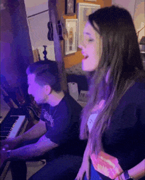 a man is playing a piano and a woman is singing next to him
