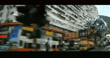 a double decker bus is driving down a busy street with a building in the background