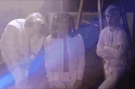 a group of people are standing next to each other in a dark room
