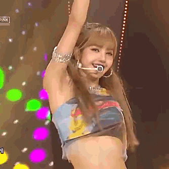 a woman in a crop top with a microphone in her mouth is on a stage .