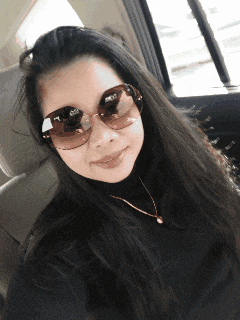 a woman wearing sunglasses and a black turtleneck is smiling for the camera