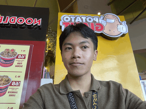 a man taking a selfie in front of a sign that says potato