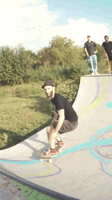 a man wearing a hat is riding a skateboard