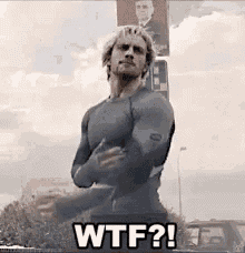 a man in a superhero costume is standing in front of a sign that says wtf ? .