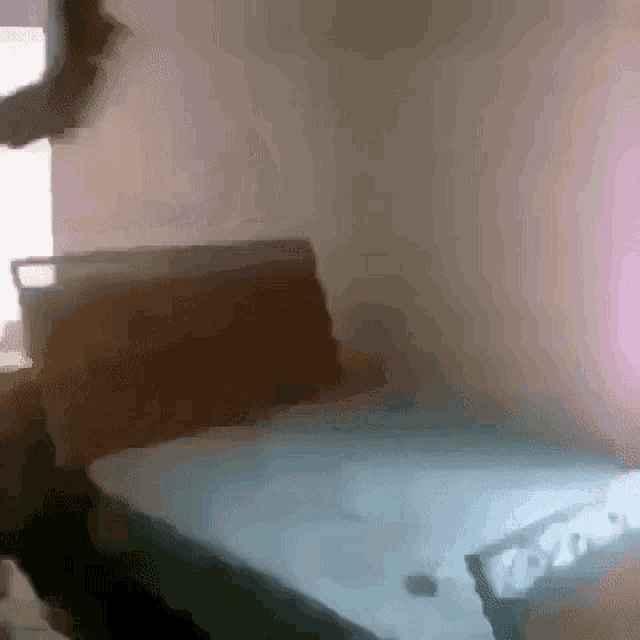 a person is standing in a bedroom next to a bed .