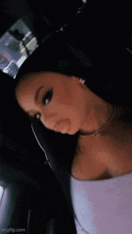 a woman is sitting in the back seat of a car wearing a necklace .