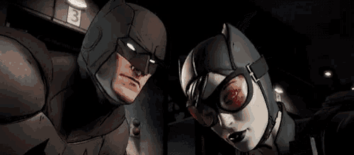 batman and catwoman are standing next to each other and looking at each other in a dark room .