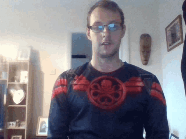 a man wearing glasses and a black shirt with a red octopus on the front