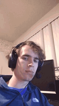 a young man wearing headphones and a north face sweatshirt