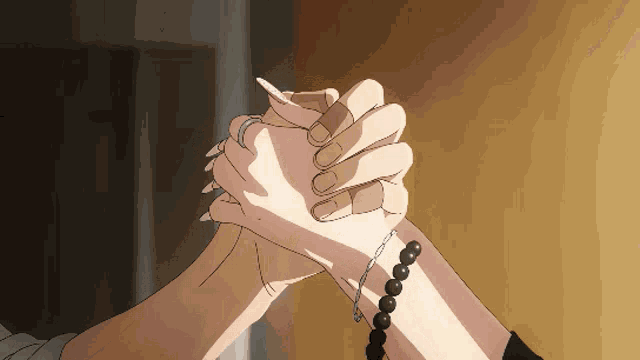 a couple holding hands with one wearing a bracelet