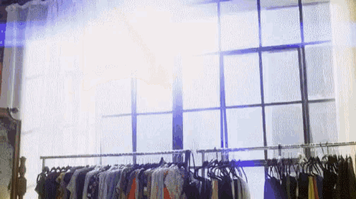 a row of clothes hangs in front of a window