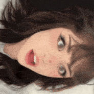 a close up of a woman laying on her back with her mouth open