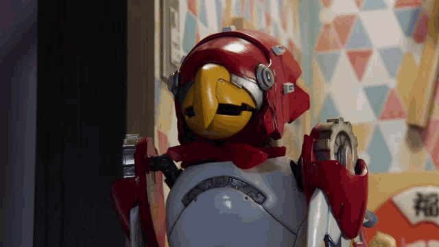 a robot with a yellow head and a red helmet has a clock on it